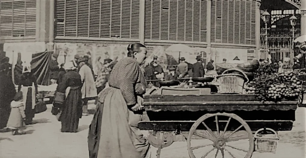 Des marchandes et leurs baladeuses devant les halles du Champ-de-Mars