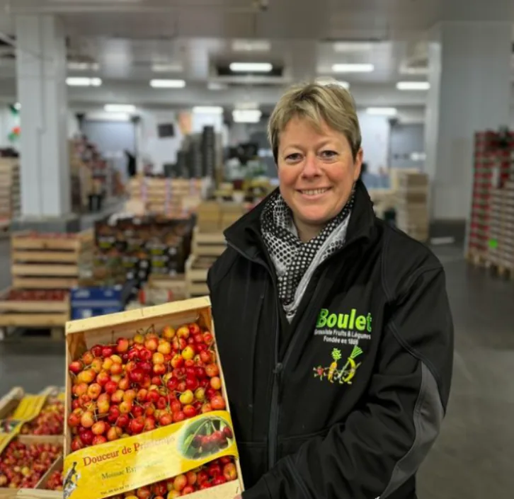 Nelly Boulet tenant une cagette de cerises dans l’entrepôt